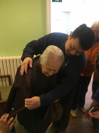 11综合党支部党员胡杰帮助董奶奶穿衣_调整大小